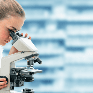 Photo of a researcher looking through a microscope in lab