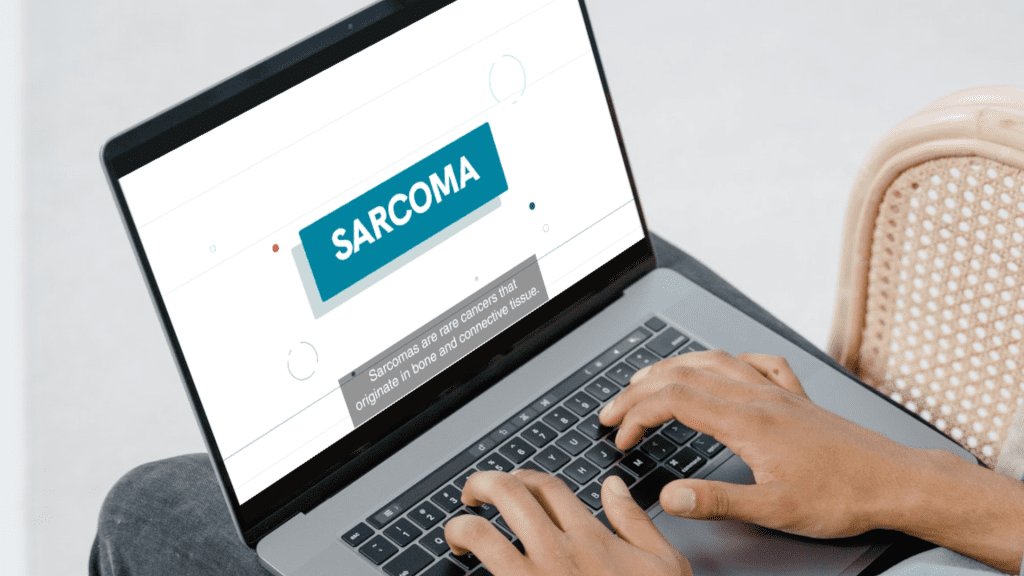 Hands on laptop keyboard, with display showing the word 'sarcoma'