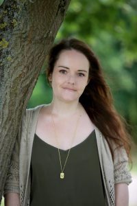 Photo of woman leaning against a tree